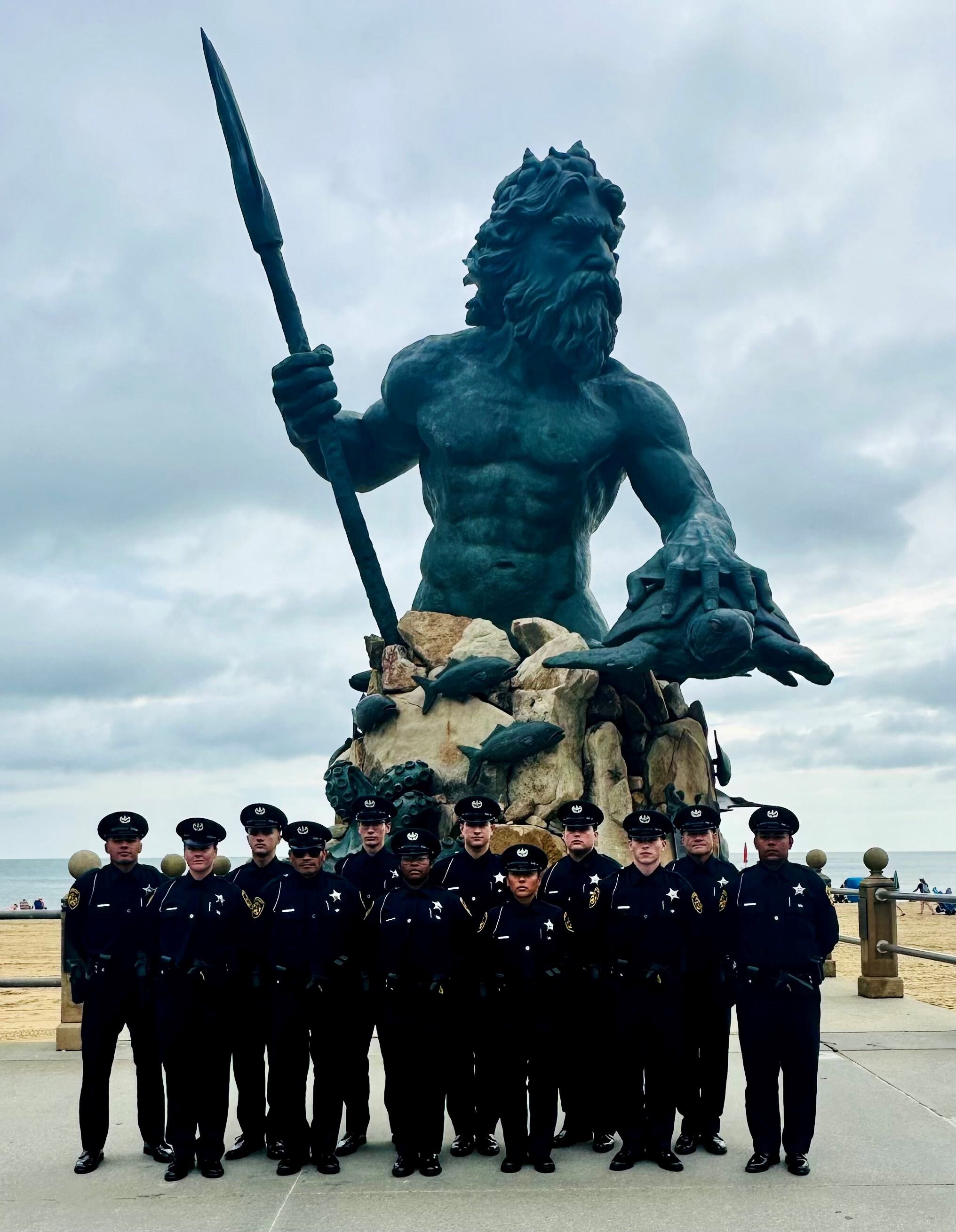 12 deputies standing in front of King Neptune statue at the beach